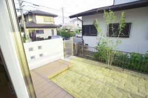 ～メインガーデン：リビングから見える風景～  リビングからちょうどシマトネリコの樹が見えるように、配置。 エバーエコウッドデッキの横に立った壁にはガラスブロックが埋め込まれていて、外をこっそり覗けます。穴をあけることによって防犯対策にもなります。