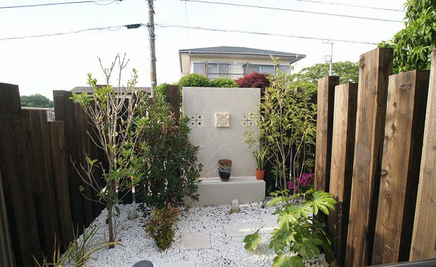 ～バスルームからの風景～  ヒメイチゴ、サンゴジュ、ツツジ、シマトネリコ、ヤツデ、イノモトソウなどなど…たくさんの植物が植えられています。 こちらは、旦那様のご要望で、バスルームから眺められる、バリ風のお庭がテーマです。 奥の壁には、穴あきブロック、オンリーワン：キュービックフォーや、ダリアのタイルが貼られいています。 床には、メイクランド：白砂利を使用し、踏み石もユーロハウス：アンティークストーンで、白を基調としたモダンなお庭に仕上げています。 夜は、マリンライトが周囲をあたたかく照らします。