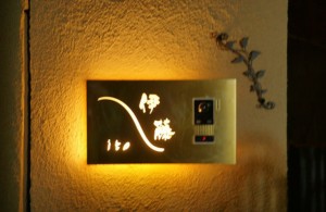 de-sign(タカショー・インターホンカバー表札)夜の写真。 光の効果で、夜でも表札がはっきり見えるので、 万が一夜にお客さまが来る場合も安心です。