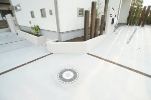 ～駐車スペース～  今回の敷地は、4つ角に位置し、斜め前が公園。よこ7く、ちいさいお子さんがこの付近で遊びまわています。4つ角の床には、遊びゴゴロを持たせて、丸い方位のタイル（四国化成：テラライト）を設置。地域のシンボルにもなります。方位の向きもきちんとあわせていますよ♪